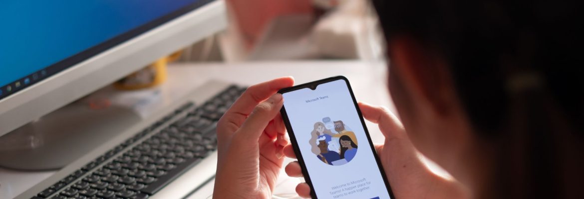 Woman holding a phone with Microsoft Teams starting